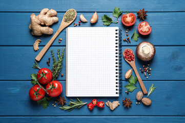 Open recipe book and different ingredients on light blue wooden table, flat lay. Space for text