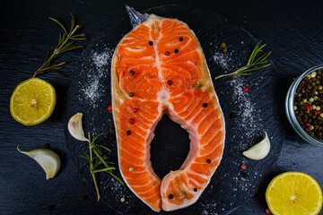 Wall Mural - Raw salmon steak and spices on a slate board. Top view