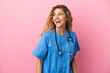 © luismolinero - Young surgeon doctor woman isolated on pink background looking to the side and smiling