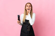 © luismolinero - Young hairdresser woman isolated on pink background shouting with mouth wide open