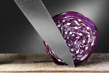 A Head Of Red Cabbage And A Carving Knife. Horizontal Format On A Rustic Wood Surface And A Light To Dark Gray Background.