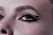 © Cavan Images - Close-up beauty shot of eye of a young pretty model with bright cat-eye make-up. Black Eyeliner. Pink lips. Gorgeous beauty portait