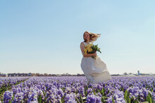 Full Length Portrait Of Woman Standing On Hyacinth Fields
