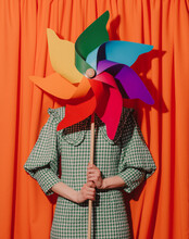 Style Woman In Green Dress With Pinwheel On Orange Curtains