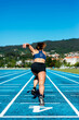 © Cavan Images - Back of woman sprinter running on an athletics track