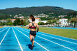 © Cavan Images - Back of a young woman athlete running on the track