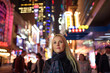 © Cavan Images - Adult woman on glowing city street in evening