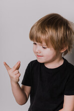 Little Cute Caucasian Boy Kid 3years Old Wearing Black T-shirt Against White Wall Showing And Pointing Up With Fingers Number Three While Smiling Confident And Happy.