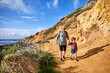 © Cavan Images - Senior woman hiking with grandson during sunny day