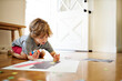© Cavan Images - Boy holding glue while making paper art at home