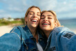 © Cavan Images - Two beautiful smiling female friends taking a selfie