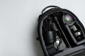 Wall Mural - professional photography equipment in backpack on grey background, top view. space for text
