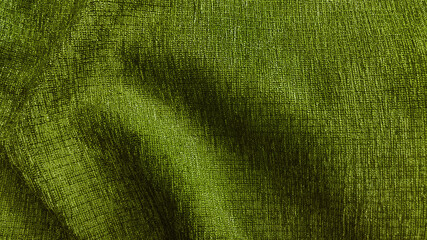 close up luxury green olive sackcloth. elegance wavy and fold grenn silk fabric texture. abstract background of fabric.