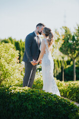 Poster - Beautiful bride and groom kissing in the garden