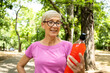 © littlewolf1989 - Senior woman ready for training holding energy drink in the park.