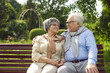 © Studio Romantic - Happy loving senior couple sitting on bench and hugging looking into eyes. Aged retired family spouses feeling love showing adoration of each other enjoy rest and time together. Retirement concept