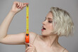 Girl with short hair shows the size using a construction tape