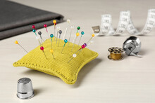 Pin Cushion And Thimble On White Table