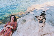 Funny Happy Portrait Of Young Woman Wearing Turkish Traditional Costume At The Sea Surprised By Stray Dog 