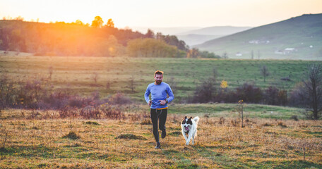 Poster - happy dog and man running in autumn field