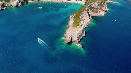 Wall Mural - Aerial view of turquoise bay in resort village of Paleokastritsa. Boat is sailing to shore. Drone shot.