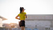 © EduLife Photos - A young Asian woman athlete runner jogging on running track in city stadium in the sunny morning to keep fitness and healthy lifestyle. Young fitness woman runs on stadium track. Sport and recreation