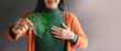 Green Energy, ESG, Renewable and Sustainable Resources. Environmental and Ecology Care Concept. Close up of Smiling Woman Holding a Heart Shape Green Leaf, presenting to Camera