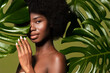 © Beauty Agent Studio - Connected with a nature. Beauty portrait of young beautiful african american woman with posing against green exotixc plants  background. Natural skin care concept