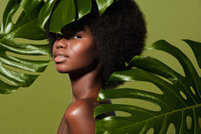 Green Beauty Portrait Of Young Beautiful African American Woman With Posing Against Green Exotixc Plants  Background. Natural Skin Care Concept