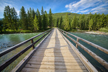 Picturesque View Of Wooden Bridge Over Pure Rapid River Flowing Near Forest At Summer Day 