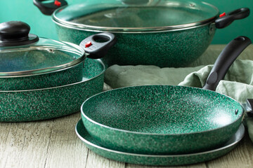 New Set Empty fry pan green with ceramic coatingon on a rustic  kitchen table.