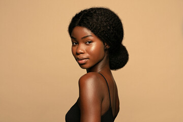 Wall Mural - portrait of beautiful african american woman with curly hair against beige background