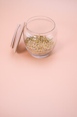 Canvas Print - Vertical shot of seeds on a canister isolated on light brown background