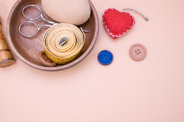 Canvas Print - Top view of sewing materials on a wooden bowl isolated on light brown background