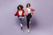© Look! - Joyful two modern ladies with brunette hairstyle and red cool sunglasses in warm sweaters, tops, pants and white sneakers jumping.