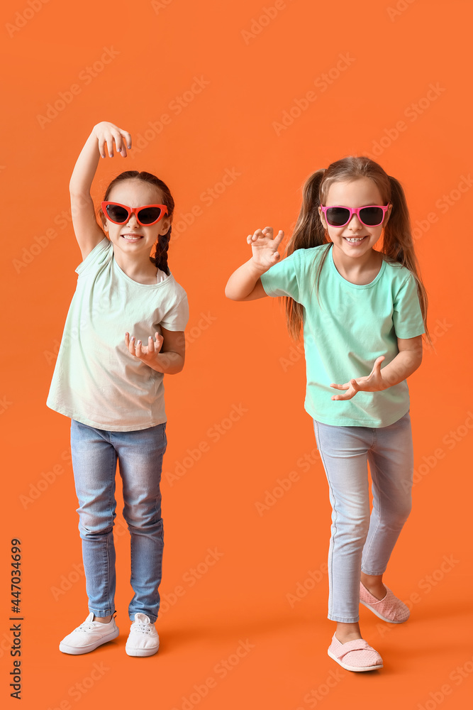 Cute little sisters on color background