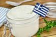 Greek yogurt and flag on wooden table