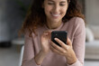 © fizkes - Crop close up of smiling young Latino woman hold cellphone talk speak on video webcam call on gadget. Happy millennial Hispanic female use smartphone shopping online. Communication concept.