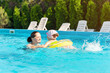 © andrei310 - Happy mother and daughter bathe in the pool on a sunny day
