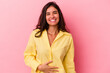 Young caucasian woman isolated on pink background touches tummy, smiles gently, eating and satisfaction concept.