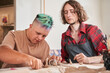 Sculptor looking how his student with special needs working at the pottery master class
