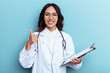 © Asier - Young doctor mexican woman isolated on blue background smiling and raising thumb up