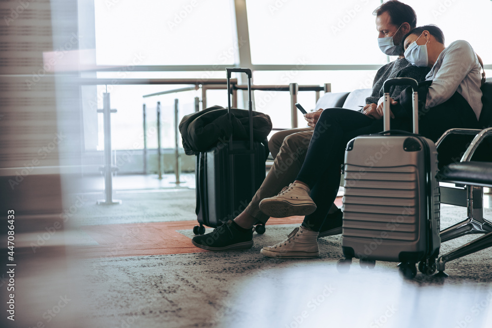 Couple during covid-19 outbreak waiting for delayed flight - obrazy, fototapety, plakaty 