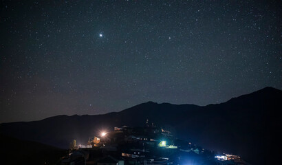 Wall Mural - the starry sky over the high mountain village of khinalig