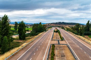 Wall Mural - Landscape of the Ruta de la Plata highway as it passes through Extremadura, Spain, with trees, low mountains and cloudy skies.