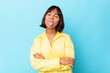 Young mixed race woman isolated on blue background funny and friendly sticking out tongue.