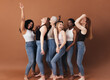 © Artem Varnitsin - Six diverse women laughing together. Females with different body types having fun while standing against a brown background.