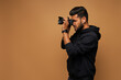 © Тарас Нагирняк - Young indian photographer in black hoody with camera on background with copy space