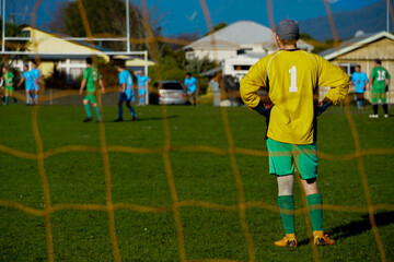 Sticker - Goalkeeper looking at his team members with the net on the foreground