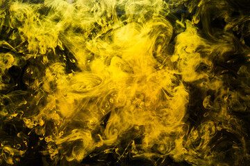 Wall Mural - Abstract liquid art, yellow smoke bomb on black background, amber color acrylic paints under water